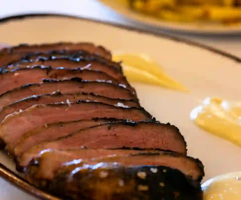 Carne a la brasa cortada en lonchas con patatas fritas caseras